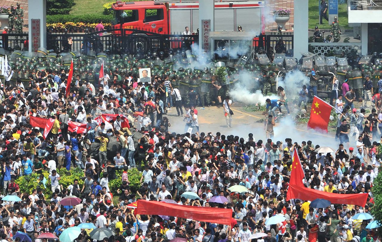 Police fire tear gas to disperse the crowds in Shenzhen, south China's Guangdong province. 