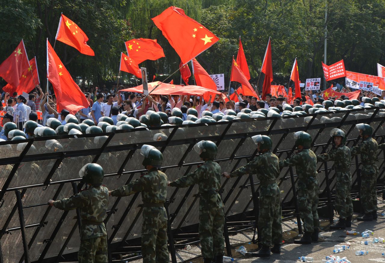 Chinese para-military police create a barrier to prevent protesters from breaching  the Japanese embassy in Beijing.