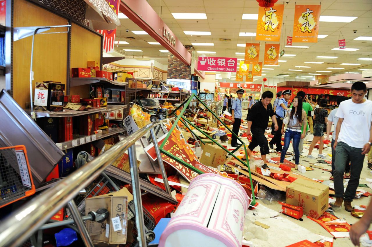 Security guards try to remove Chinese protesters who ransacked Japan's JUSCO departmental store, in Qingdao on September 15. 