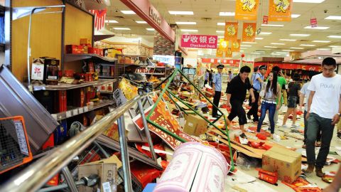 Security guards try to remove a group of Chinese protesters who ransacked Japan's JUSCO departmental store, in Qingdao.