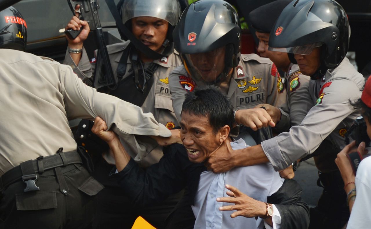 Indonesian anti-riot police arrest a protester Monday outside the U.S. Embassy in Jakarta. Monday's demonstrations come nearly a week after protests erupted in Egypt and Libya, spreading to more than 20 nations.