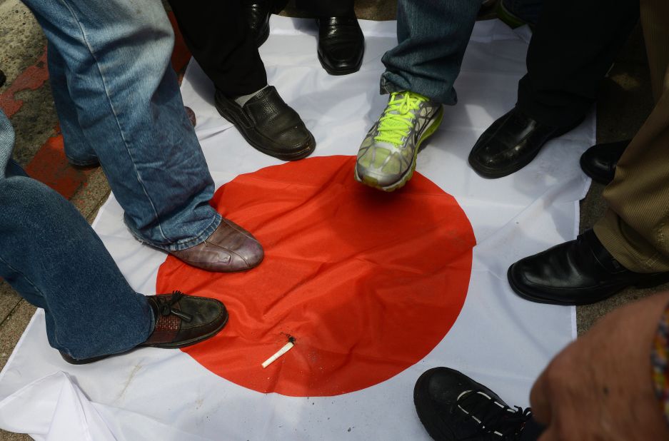 Anti-Japan activists step on a Japanese flag on September 18 during a protest in front of the parliament building in Taipei to demand the Taiwan government cooperate with China against Japan.