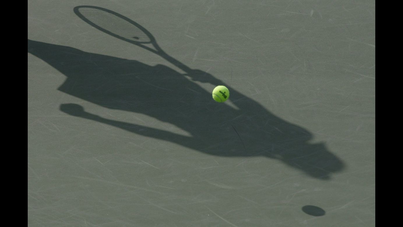 A shadow is cast across the court as Denmark's Caroline Wozniacki  serves against  Arantxa Rus of the Netherlands, during the first day of the Korea Open at Olympic Park Tennis Stadium on Tuesday in Seoul, South Korea.