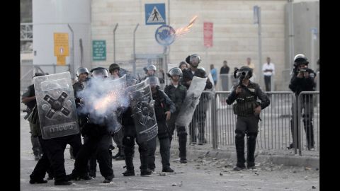 Israeli border policemen fire tear gas toward Palestinian protesters on Tuesday.