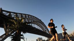 People jog along the Sydney Harbour with the Sydney Harbour bridge seen in the background on September 10, 2012. The iconic landmark is one of the top attractions in Sydney. AFP PHOTO/ROMEO GACAD (Photo credit should read ROMEO GACAD/AFP/GettyImages) 