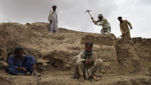Locals from relocated villages near Mes Aynak remove dirt and rocks to expose buried artifacts.