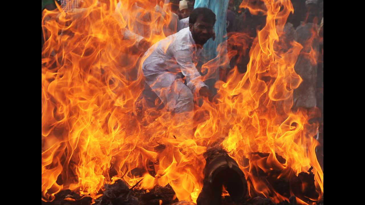 An Indian Muslim student hits a burning effigy of U.S. President Barack Obama during a protest in Kolkata on Wednesday.