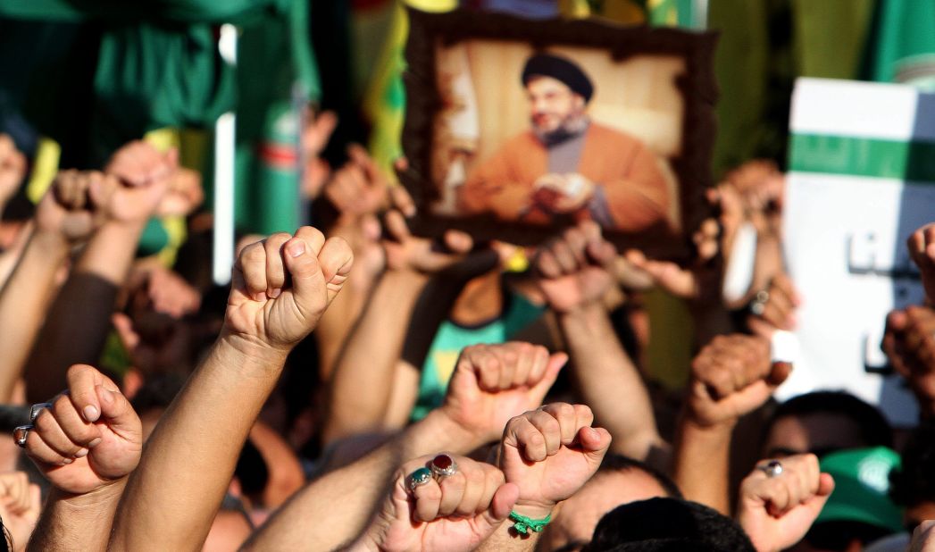 Supporters of Hezbollah hold a picture depicting Hezbollah leader Hassan Nasrallah and chant the slogan "God is Great" during a mass rally in Tyre, Lebanon, on Wednesday. Thousands of Lebanon's Hezbollah followers protested against the United States and France for a film and cartoons mocking the Prophet Mohammed. 