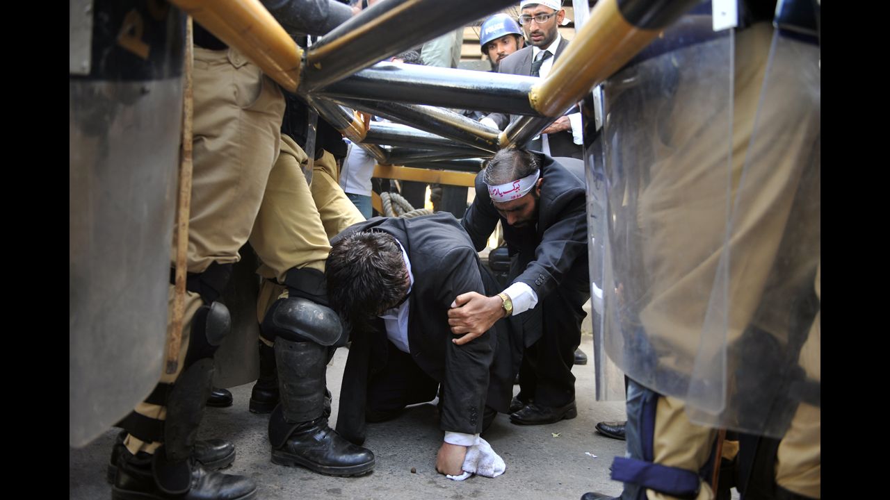 Police try to stop Pakistani lawyers crawling under a barrier as they try to reach the U.S. Embassy in the diplomatic enclave during a protest against an anti-Islam movie in Islamabad on Wednesday. 