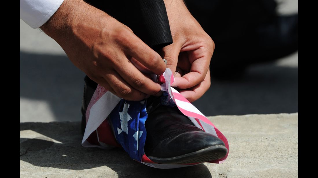 A Pakistani lawyer wraps a U.S. flag onto his shoe in Islamabad on Wednesday.
