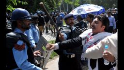 Pakistani riot policemen hold back lawyers shouting anti-US slogans as they attempt to reach the US embassy in the diplomatic enclave during a protest against an anti-Islam movie in Islamabad on September 19, 2012. Up to 500 Pakistani lawyers on  managed to enter the heavily guarded diplomatic enclave in a fresh wave of protests that erupted across Pakistan to denounce an anti-Islam film. More than 30 people worldwide have died in incidents linked to the trailer for "Innocence of Muslims," a US-made film that depicts the Prophet Mohammed as a thuggish womaniser.  AFP PHOTO / AAMIR QURESHI        (Photo credit should read AAMIR QURESHI/AFP/GettyImages)