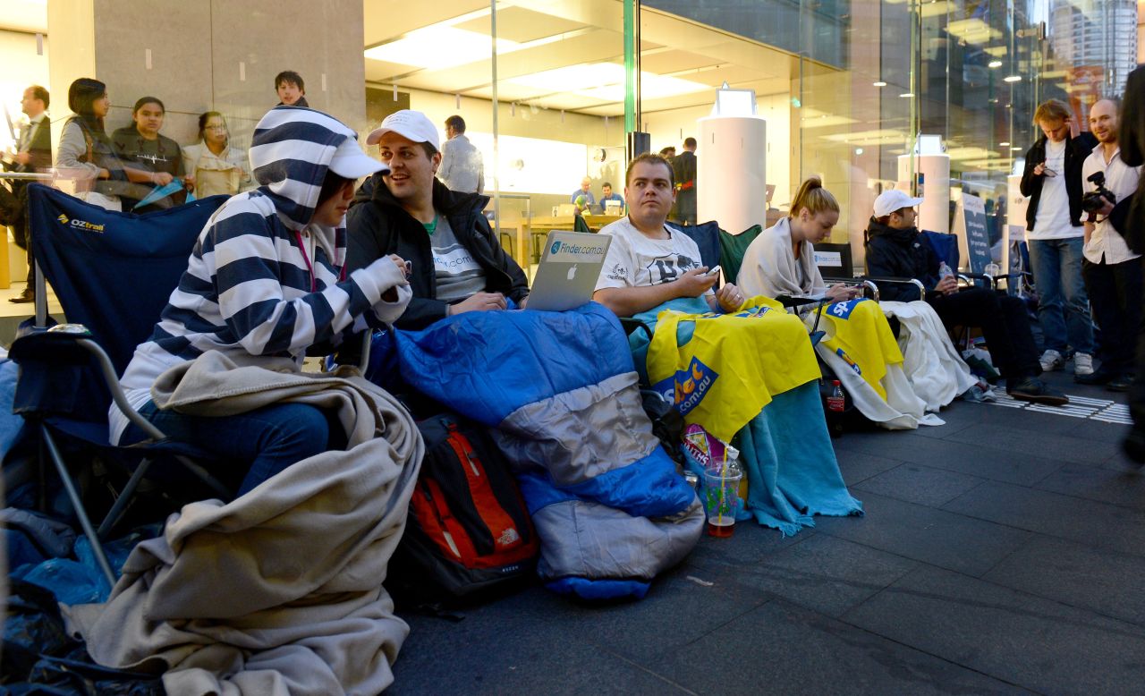 From New York to Tokyo, people are already lining up outside Apple stores to buy the iPhone 5, which goes on sale Friday. Here, people sit in a queue outside Apple's flagship store in Sydney on Thursday.