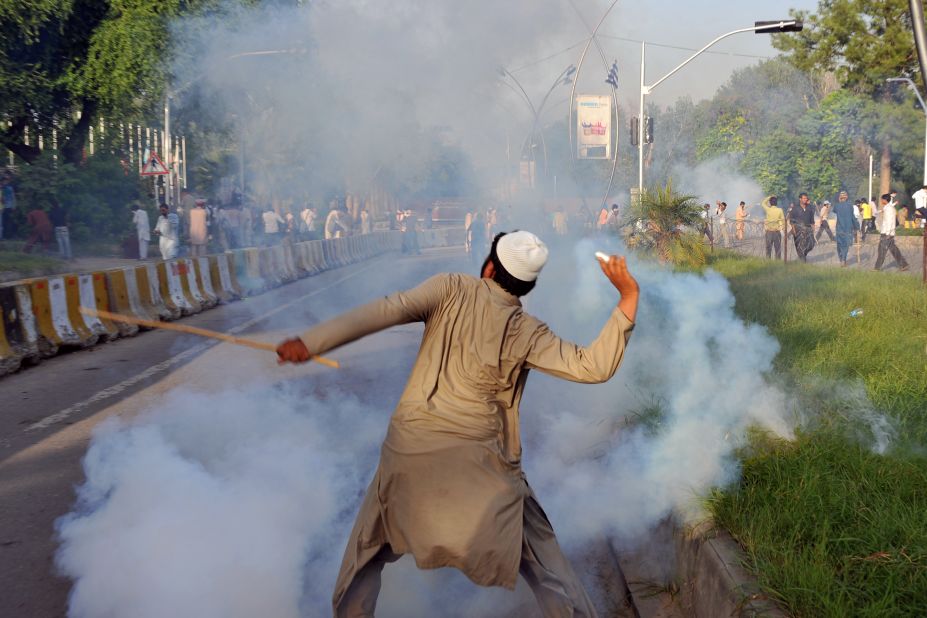 A Pakistani protester throws a tear gas shell back toward police on Thursday. 