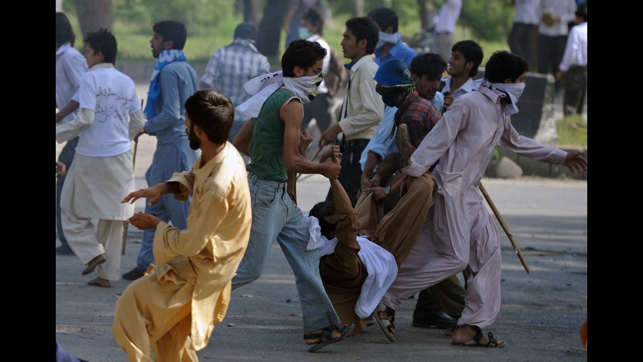 Pakistani demonstrators carry an injured person on Thursday.