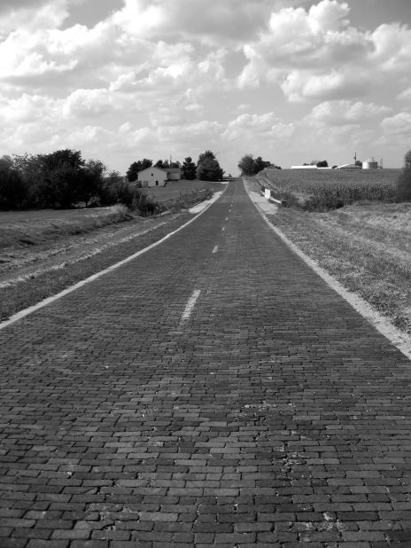 The so-called "most famous highway in the world," Route 66's surface varied from pavement to dirt to brick, shown here near Auburn, Illinois. 