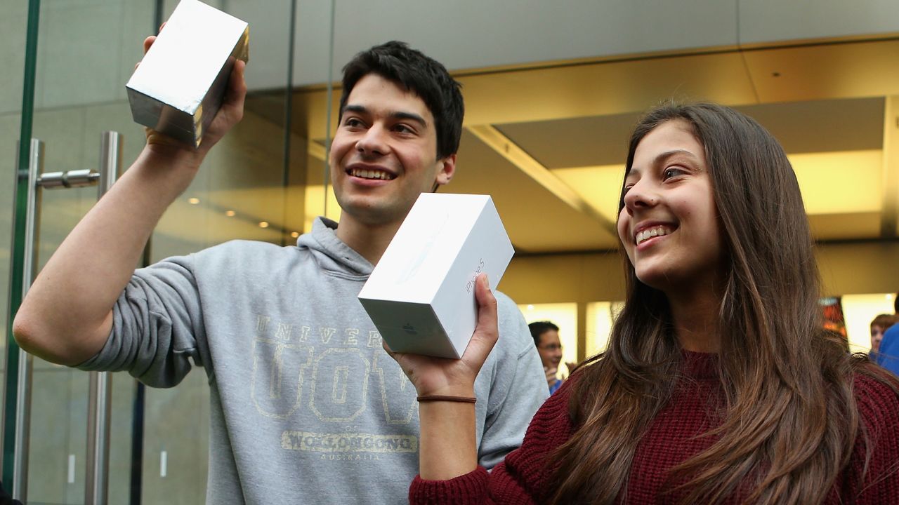 The first customers to purchase their new iPhone 5s exit an Apple store in Sydney, Australia.