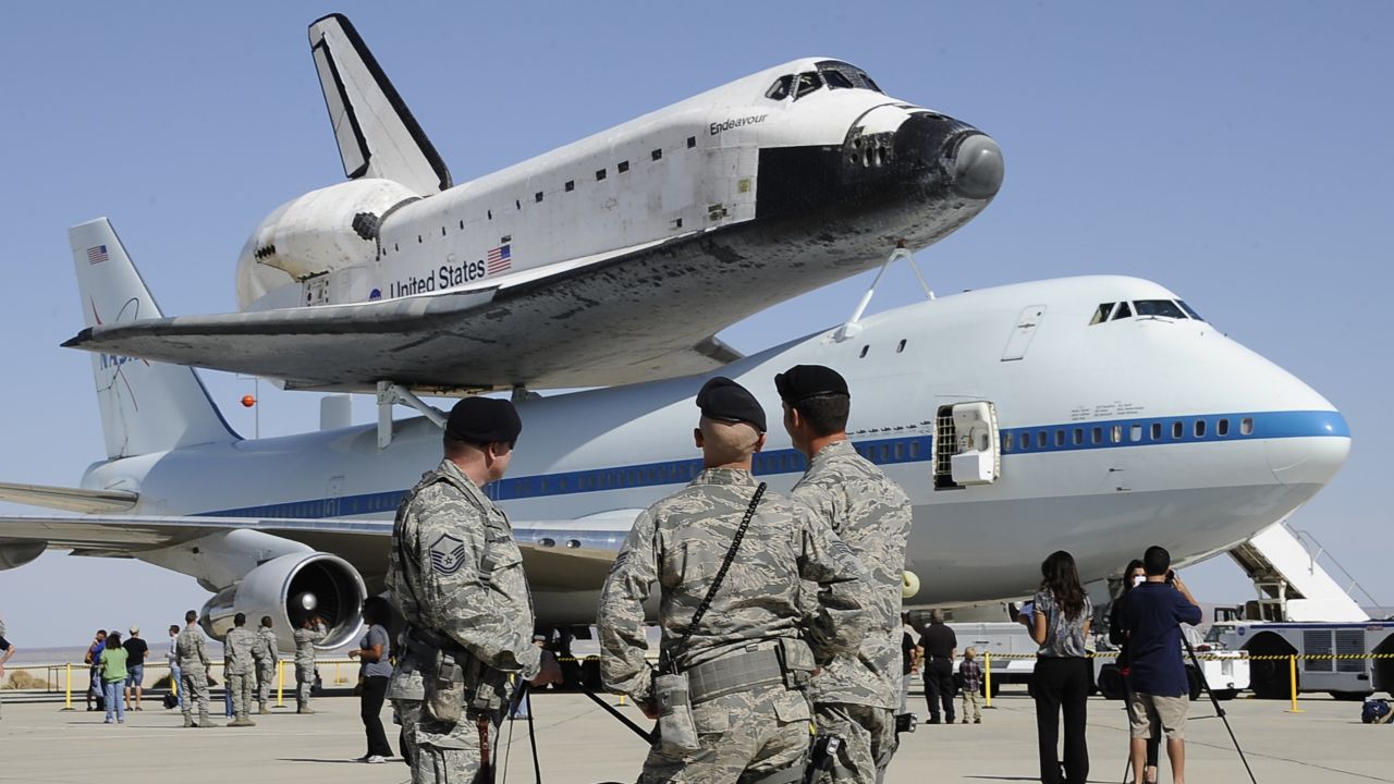Military personnel look at Endeavour atop the modified Boeing 747 at Edwards Air Force Base on Thursday. Endeavour, along with space shuttles Discovery, Enterprise and Atlantis, became a museum piece after NASA ended its 30-year shuttle program in July 2011.