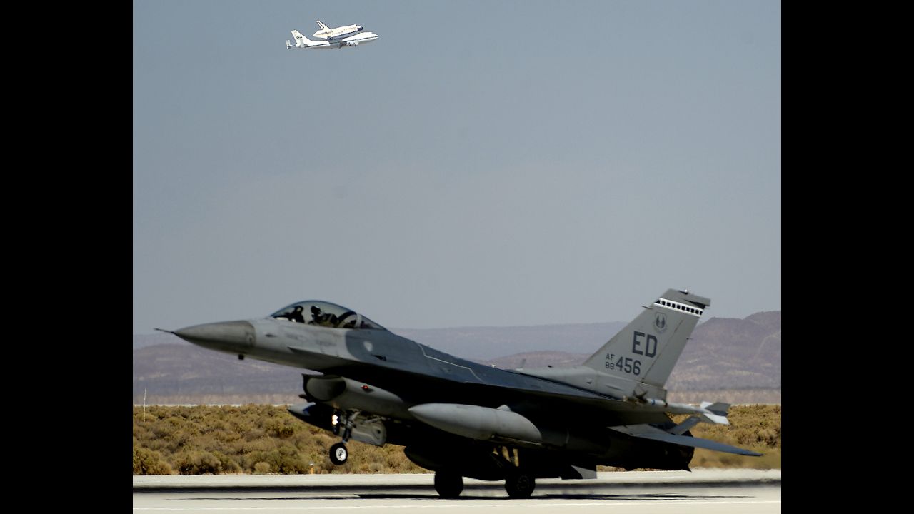 An F-16 fighter jet is seen in the foreground as Endeavour makes a flyby Thursday before landing at Edwards Air Force Base.