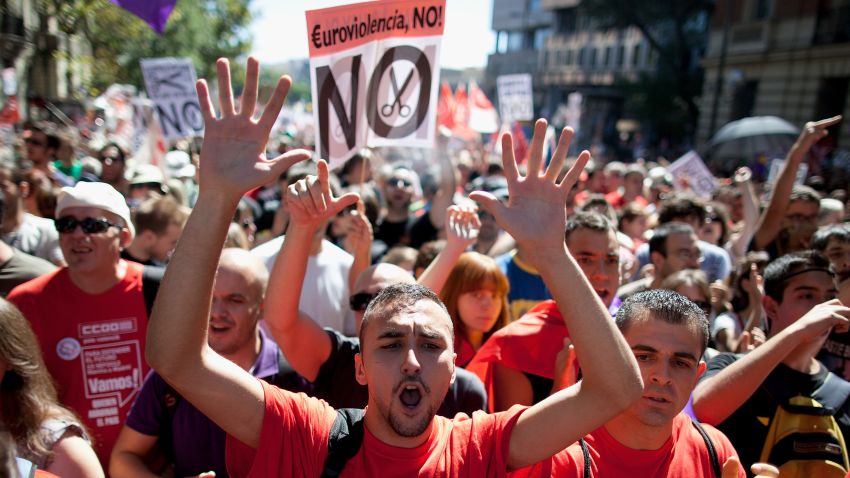 Spanish workers shout as they demonstrate against the government's austerity measures on September 15, 2012 in Madrid, Spain. Placard reads 'No Euroviolence'. Organized by Spain's two leading trade unions, UGT and CCOO, tens of thousands of people marched in the capital to protest against the government's austerity measures aimed at slashing the public deficit and avoiding a financial bailout. (Photo by Pablo Blazquez Dominguez/Getty Images)