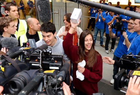 Tamsyn Vohradsky holds up her iPhone 5 after becoming the first buyer of Apple's new smartphone at a store in Sydney, Australia, on Friday, September 21.