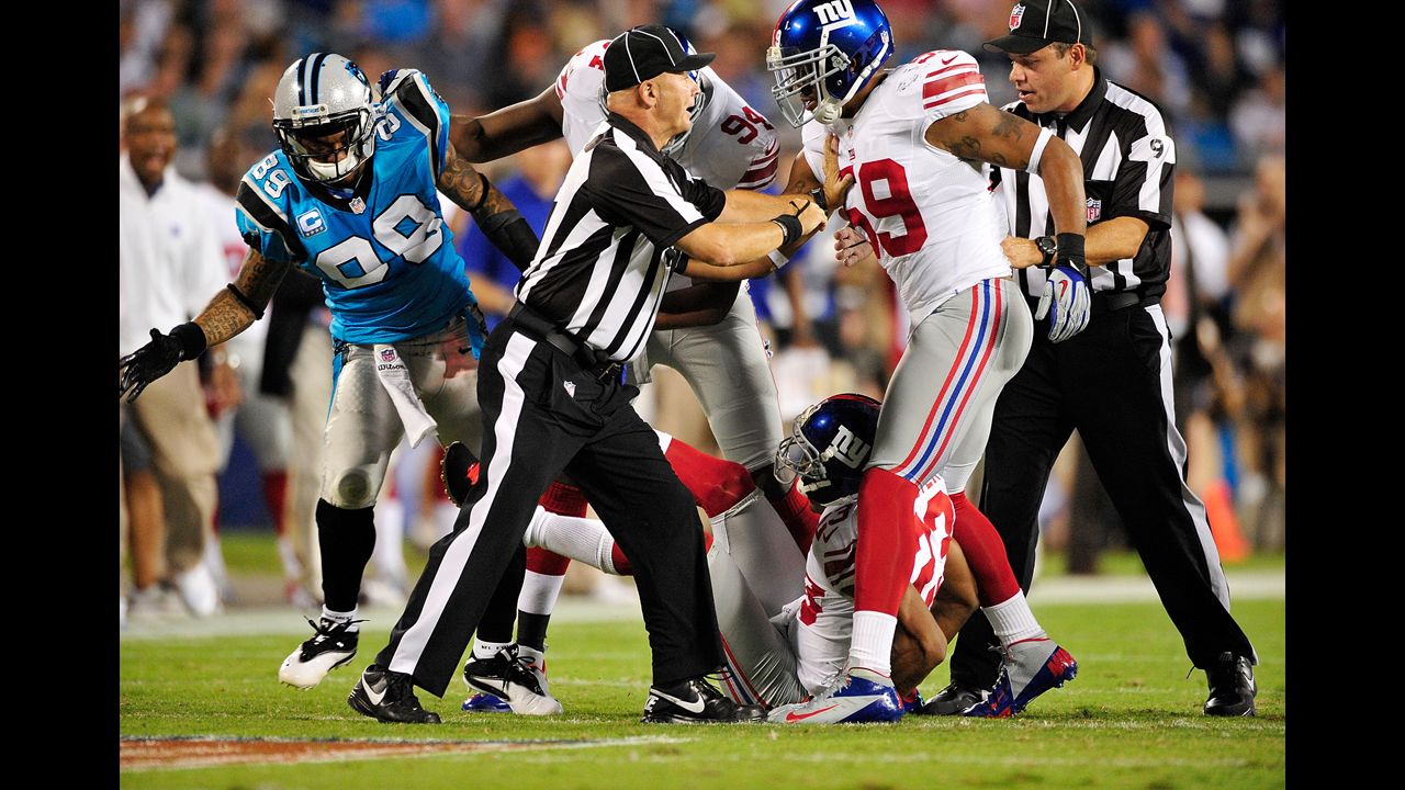 Officials separate the Giants' Michael Boley from the Panthers' Steve Smith as they scuffle after a play.
