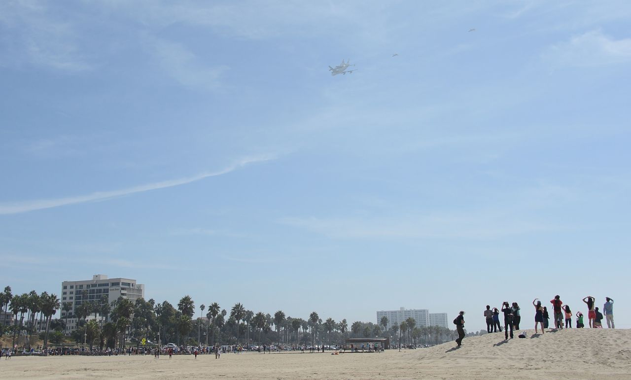 People at Santa Monica Beach watch the space shuttle arrive in Los Angeles on Friday.