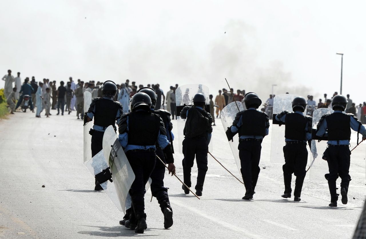 Pakistani riot police chase demonstrators Friday in Islamabad. 