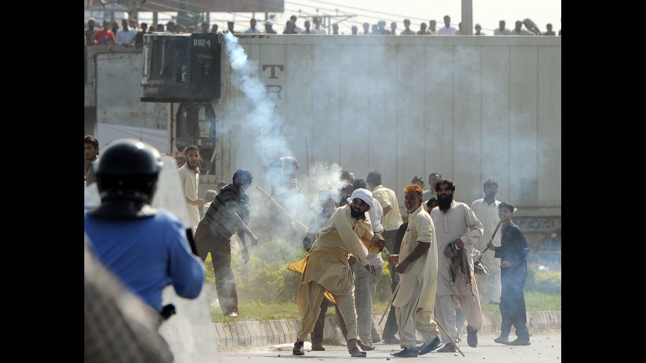 A Pakistani demonstrator throws a tear gas shell toward riot police during a protest against an anti-Islam film in Islamabad on Friday, September 21. Angry demonstrators set fire to two movie theaters in Pakistan's northwestern city of Peshawar as many braced for intensified protests Friday, officials said.