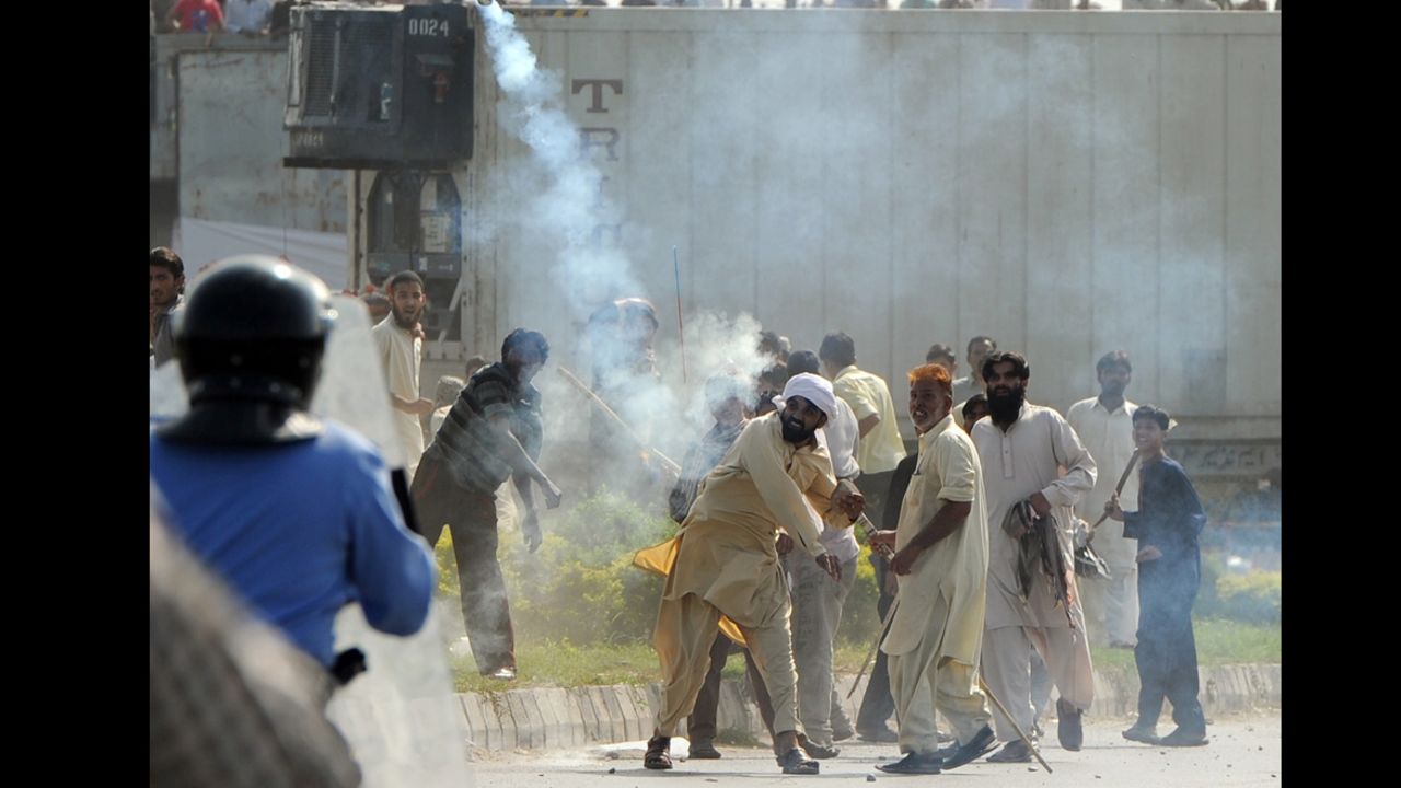 A demonstrator in Islamabad, Pakistan, throws a tear gas shell at riot police during a protest Friday against an anti-Islam film.