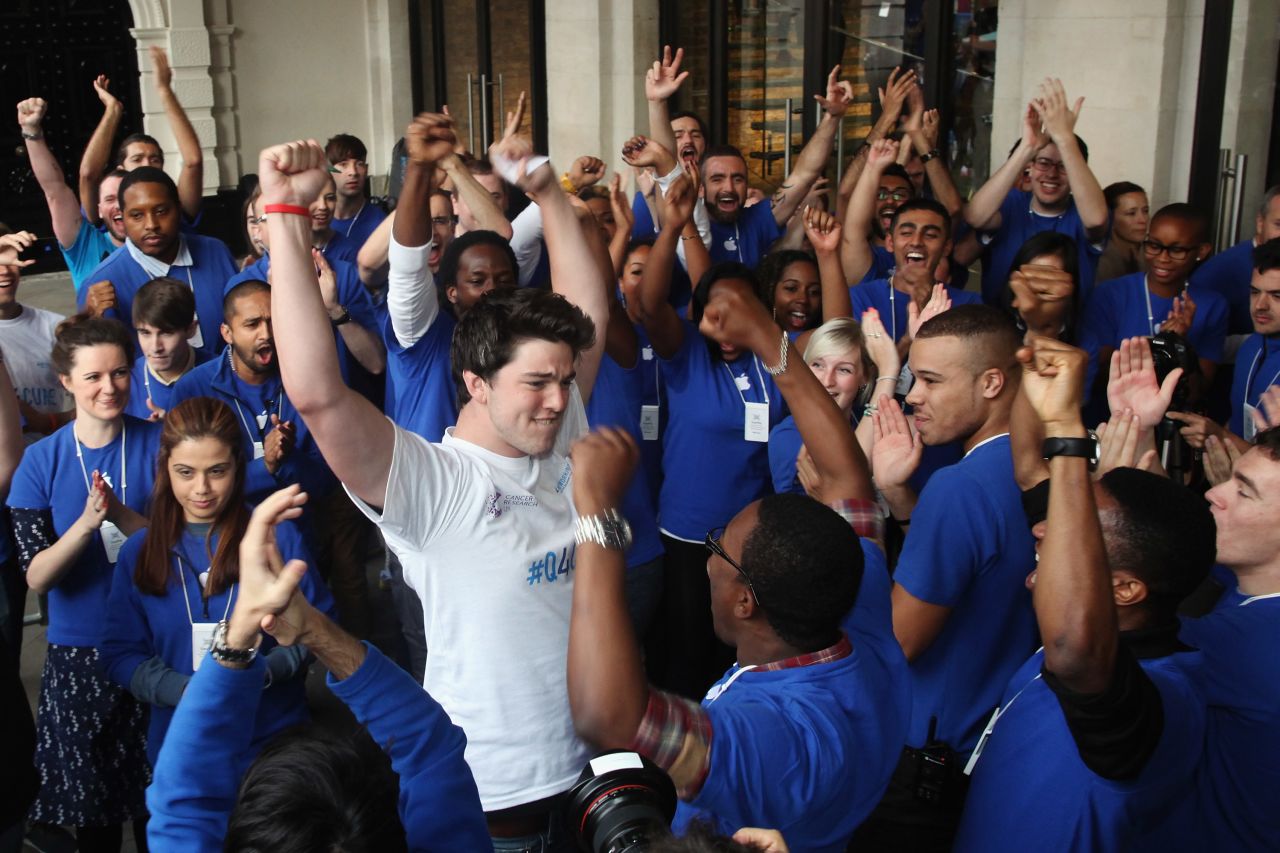 Ryan Williams, 22, of Kent, is cheered by Apple employees as he is let into the Apple Store in London, becoming the first to purchase the iPhone 5 smartphone in London on Friday.