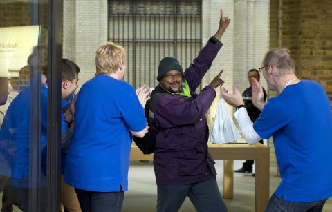 Apple Store employees applaud a customer after his new purchase. 