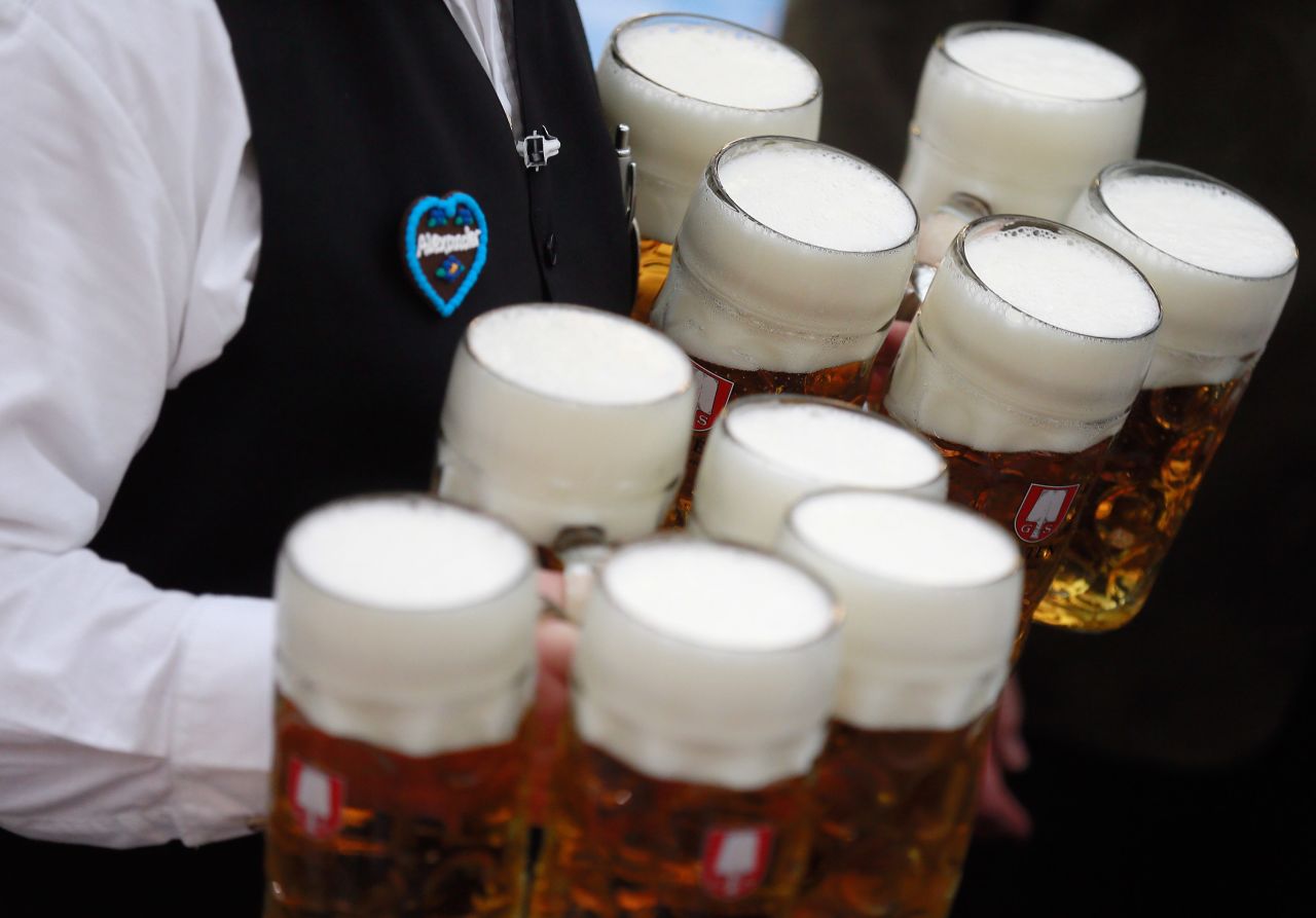 A waiter brings beer mugs to participants.