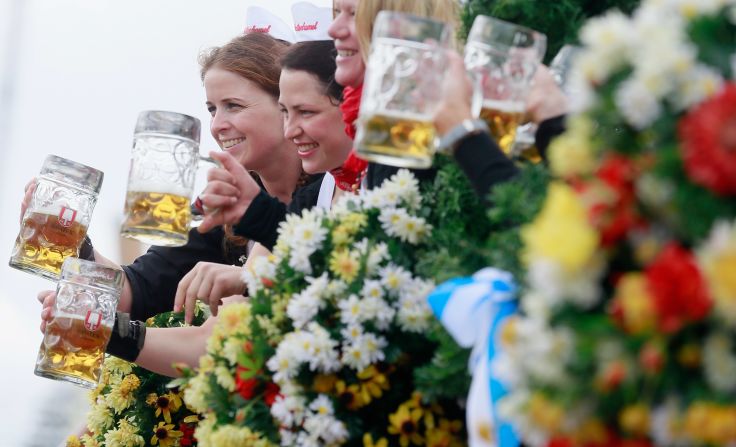 Waitresses of the Spaten brewery wave with beer mugs. <a target="_blank">See more of CNN's best photography</a>.
