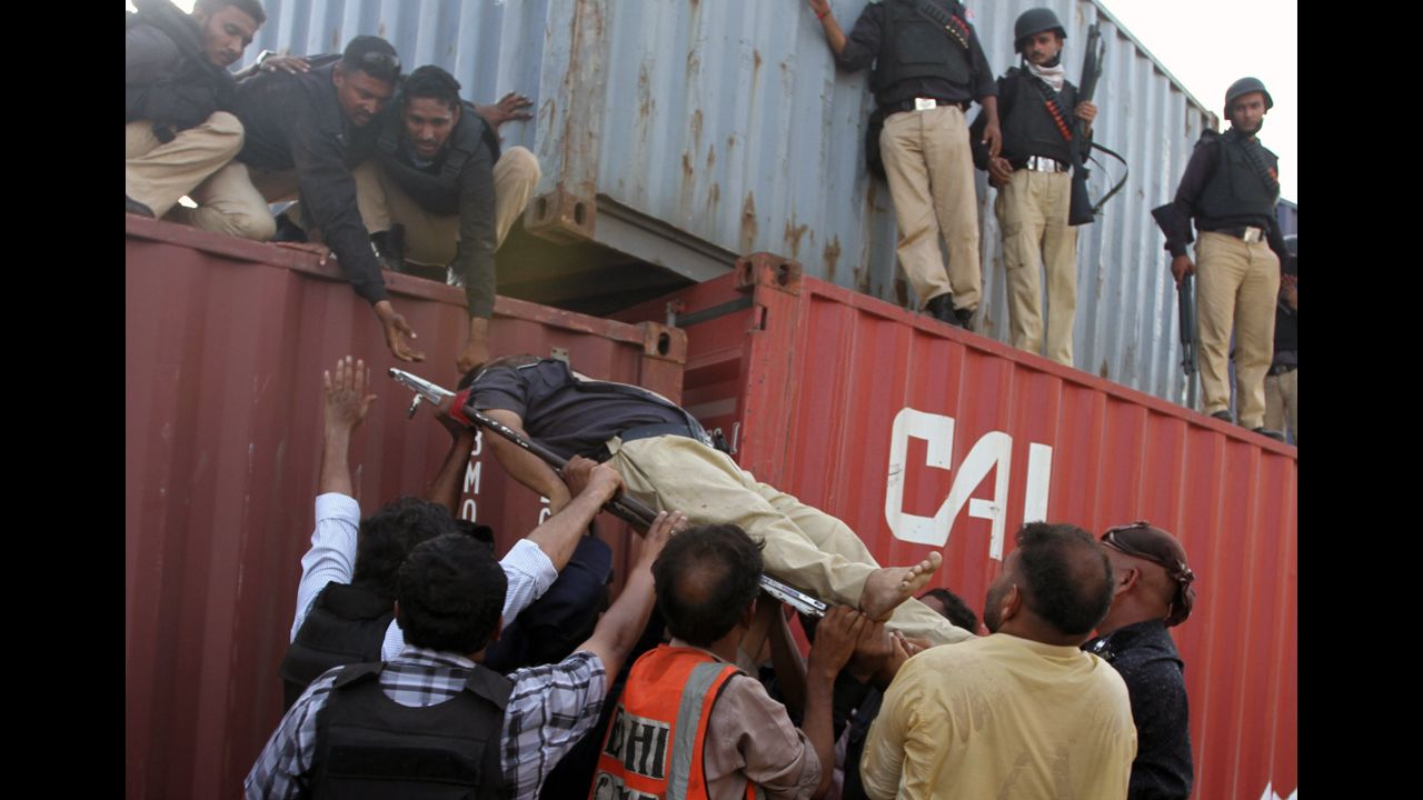 Pakistani policemen help an injured comrade Friday in Karachi.