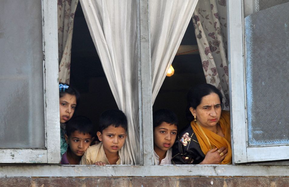 A family in Kashmir watches as students protest on Saturday.