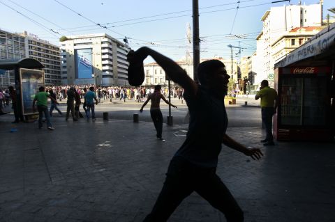  A Muslim protester throws a shoe at police during a rally in central Athens on Sunday.