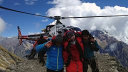 Rescuers assist a climber after an avalanche Sunday at Mount Manaslu, part of the Nepalese Himalayan mountain range.