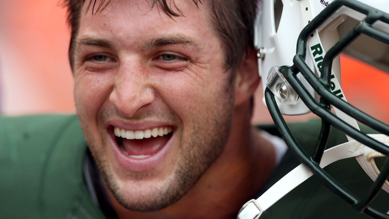 New York Jets backup quarterback Tim Tebow smiles before Sunday's game against the Dolphins.