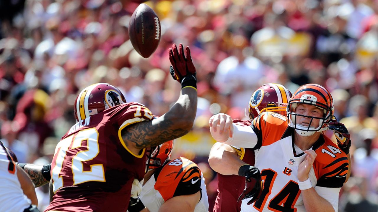 Bengals quarterback Andy Dalton is hit as he throws a pass. The Redskins' Rob Jackson would intercept and return it for a touchdown.