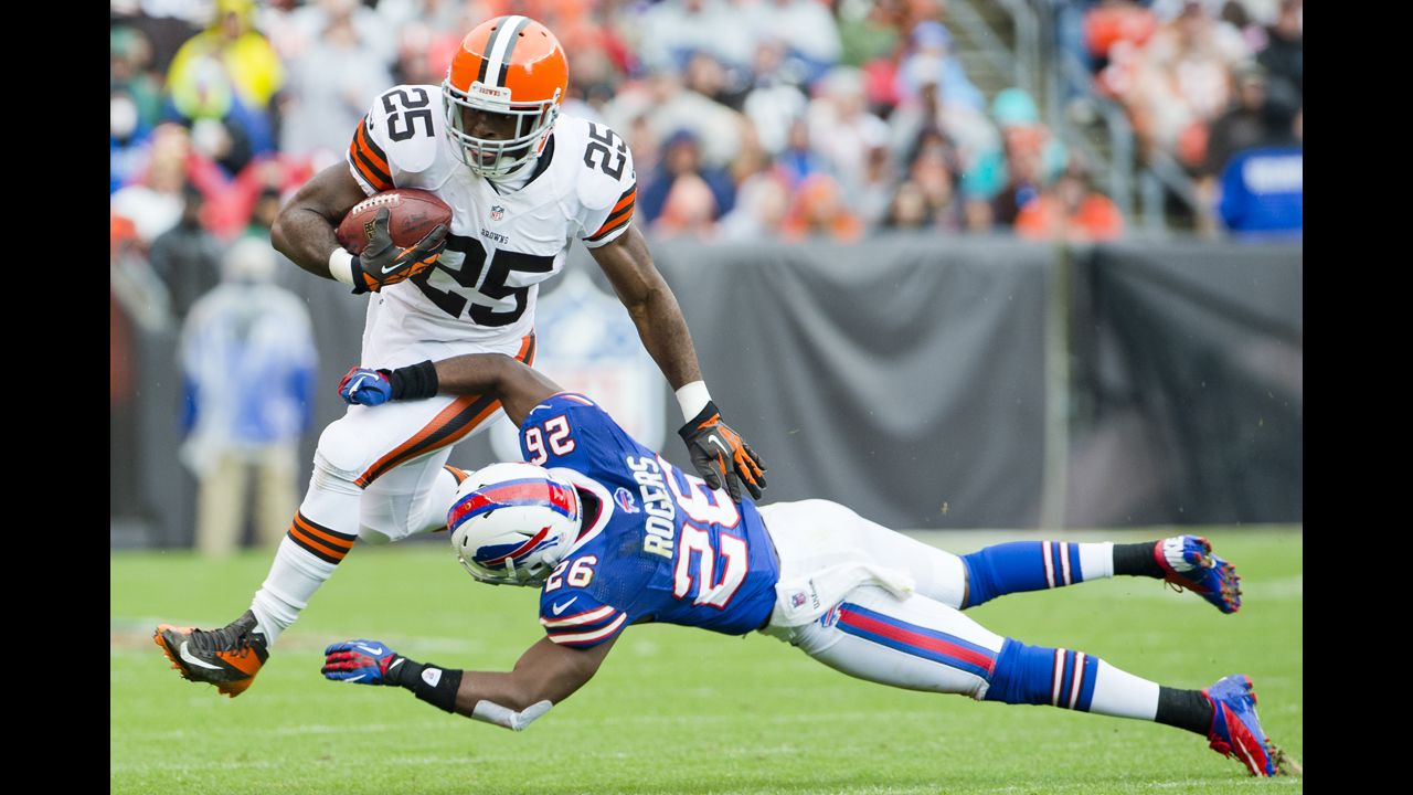 Chris Ogbonnaya of the Browns jumps over Justin Rogers of the Bills on Sunday.