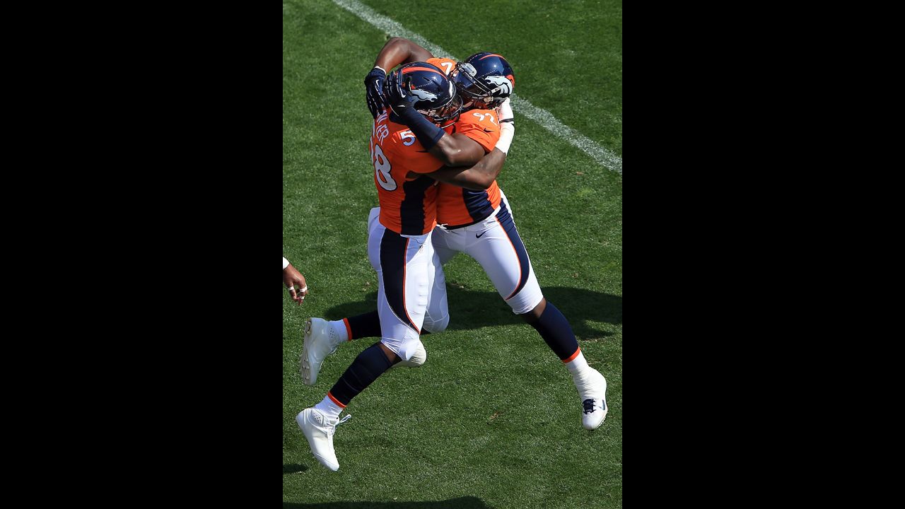 Elvis Dumervil of the Broncos, right, celebrates his safety with Von Miller on Sunday against the Texans.
