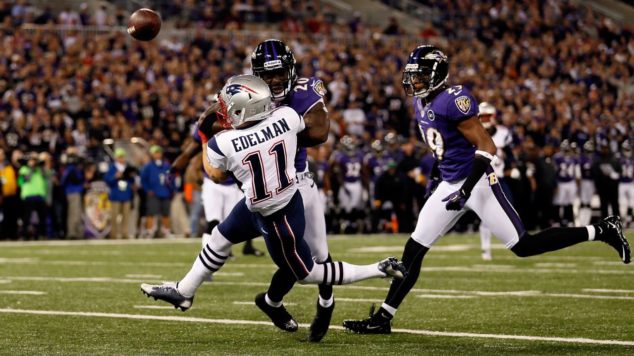 Ed Reed of the Ravens breaks up a pass as he hits the Patriots' Julian Edelman in the first quarter.