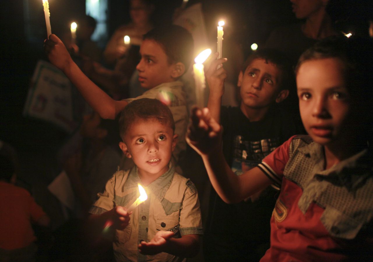 Niños palestinos sostienen velas durante una vigilia de solidaridad con la gente de Siria en septiembre en un campo de refugiados.