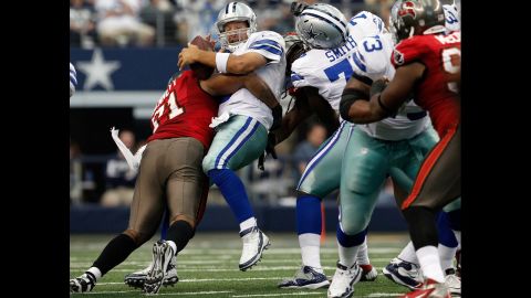 Tony Romo of the Dallas Cowboys fumbles the ball Sunday after being hit by Michael Bennett of the Tampa Bay Buccaneers.
