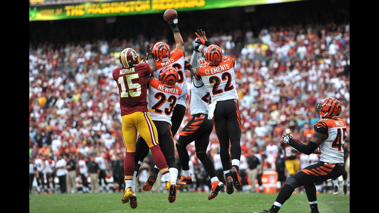 Bengals and Redskins players leap for the ball.
