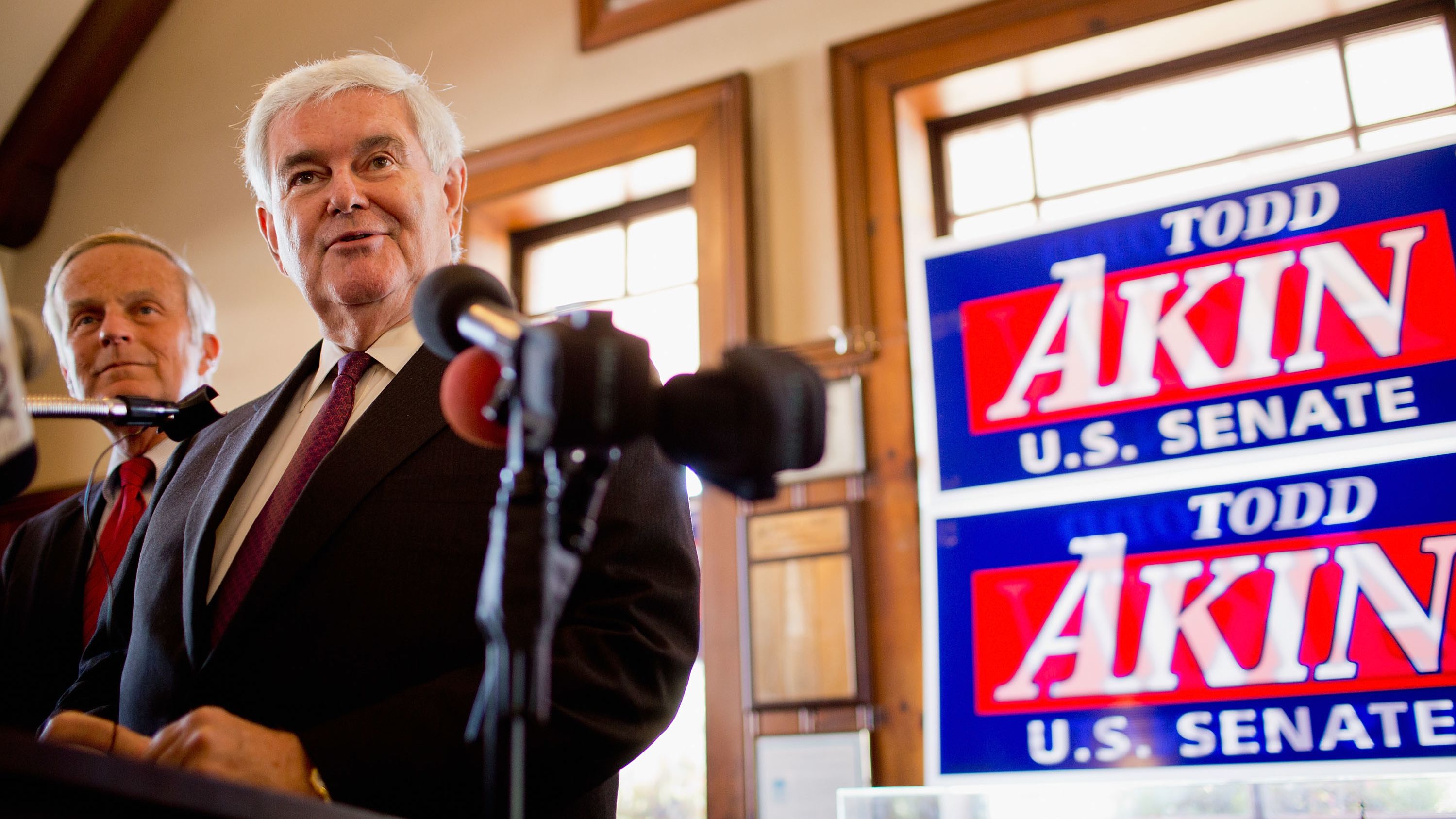Former House Speaker Newt Gingrich is backing the embattled Senate bid of Rep. Todd Akin, background. 