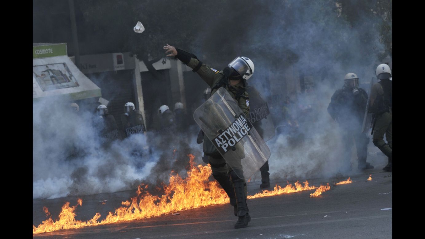 A police officer throws a stone toward demonstrators Wednesday.