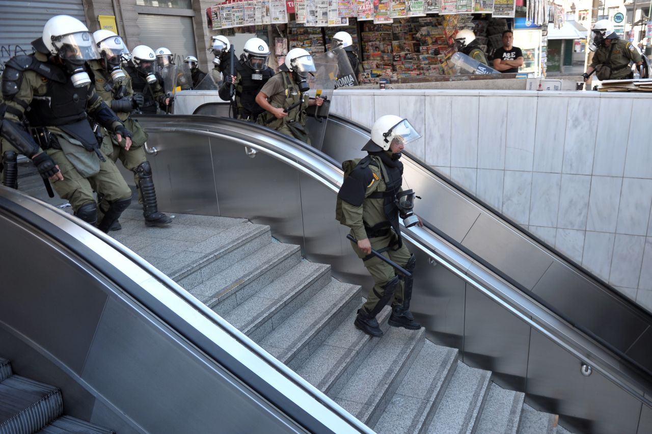 Police chase rioting youths at a subway entrance in the center of Athens Wednesday.