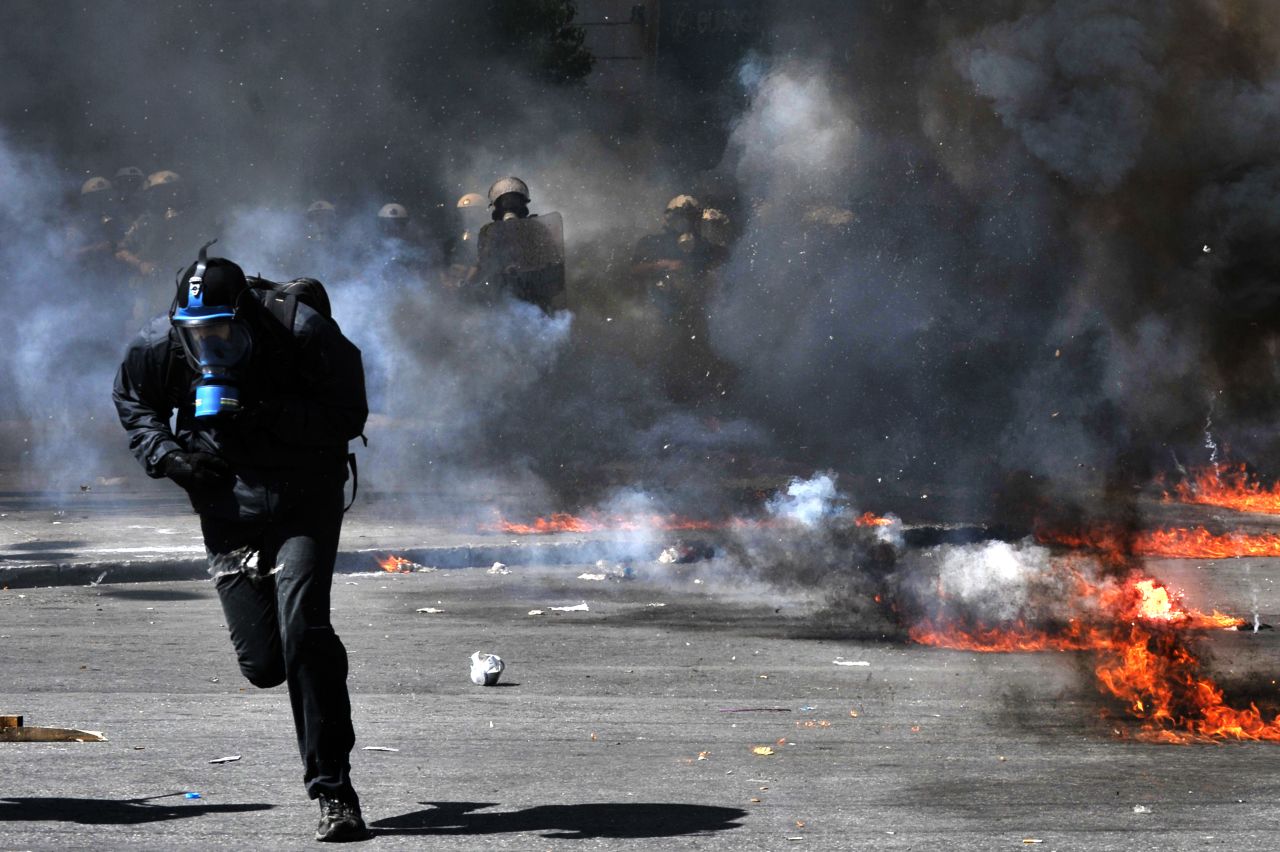 A protester runs from riot police Wednesday.