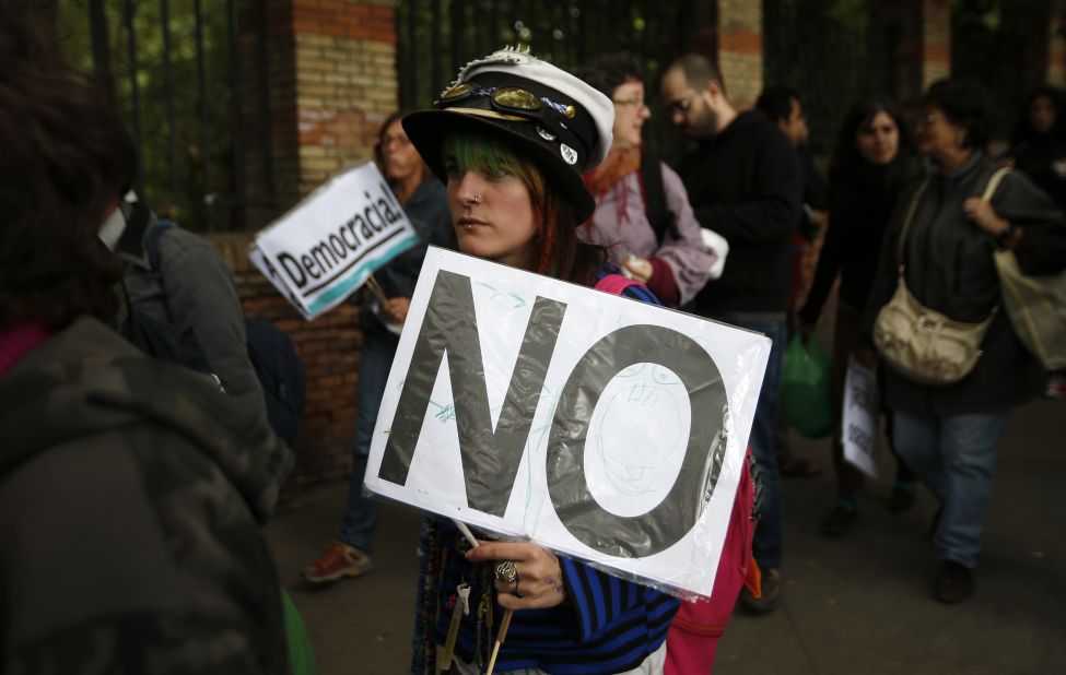A protester carries a sign as she walks toward the Spanish Parliament to join the demonstration.